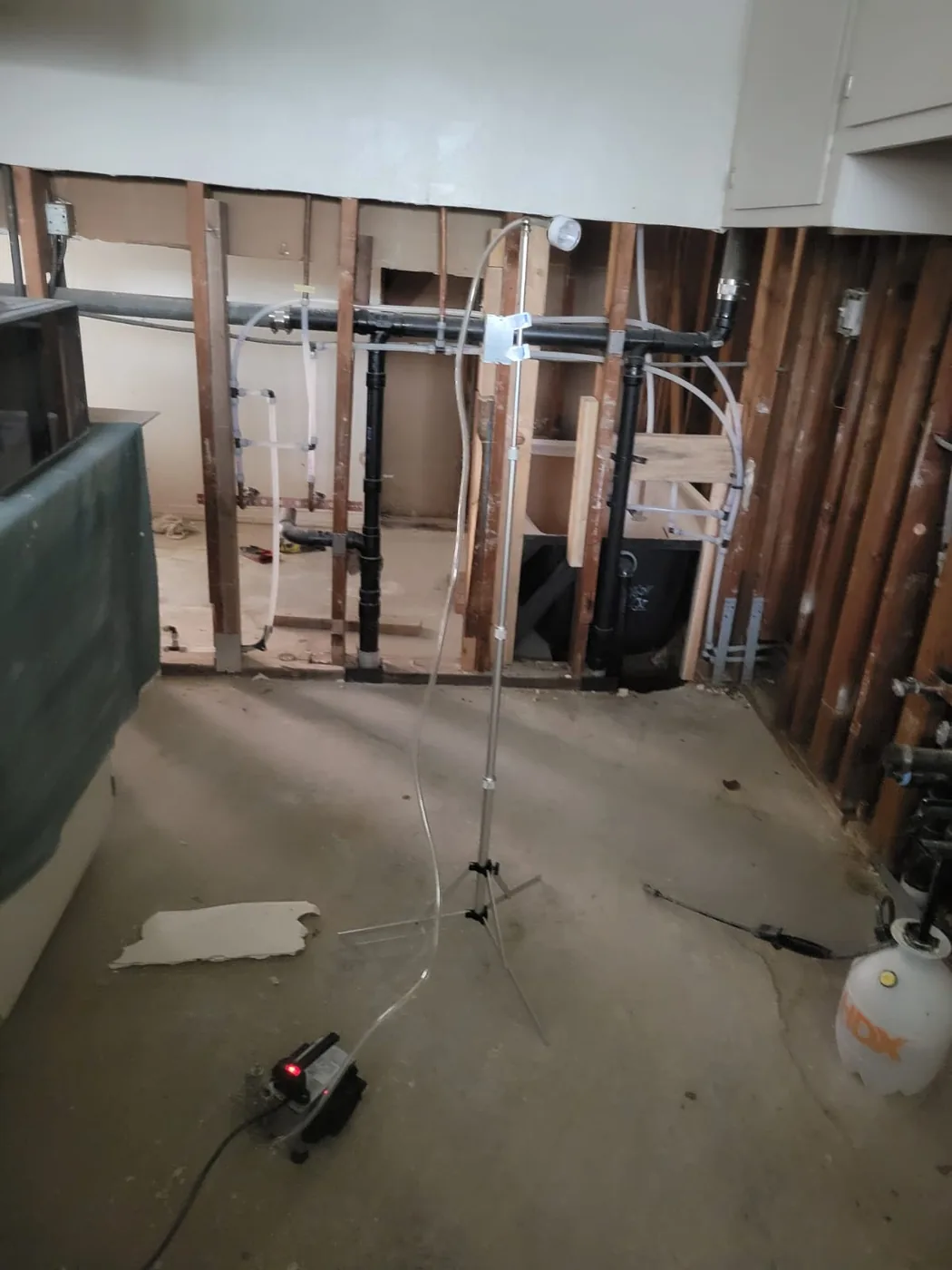 Room stripped to bare studs with air-sampling equipment running to verify the space before rebuild.